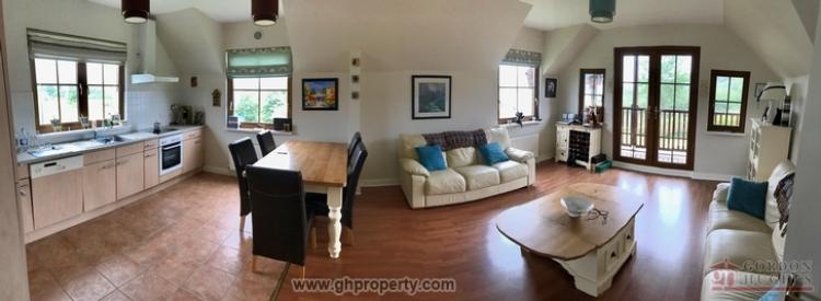 The large dining/kitchen area has doors opening on to a balcony.