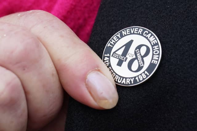 A family member touches her Stardust lapel pin on her way into Dublin Coroner’s Court (Brian Lawless/PA)