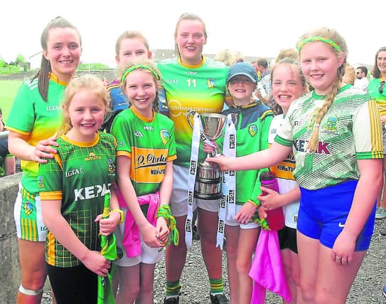 Players Carla Le Guen and Michelle Guckian pictured with a group of young Leitrim supporters and the Gift of Life Cup following Leitrim's Connacht Intermediate Final victory Picture: Willie Donnellan