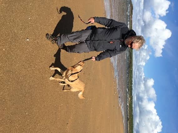 Des and his guide dog Paige walking at Tullan Strand