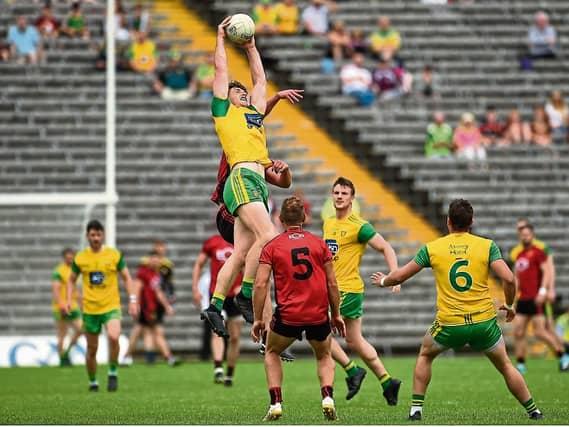 ABOVE: Hugh McFadden of Donegal in action against Peter Turley of Down TOP: Ryan McHugh of Donegal leading the players on to the pitchPhoto by Oliver McVeigh/Sportsfile