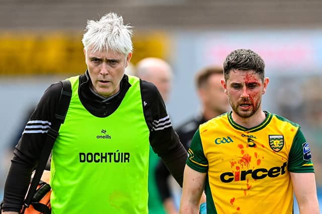 Dr Charlie McManus is pictured helping Ryan McHugh off the field last weekend.