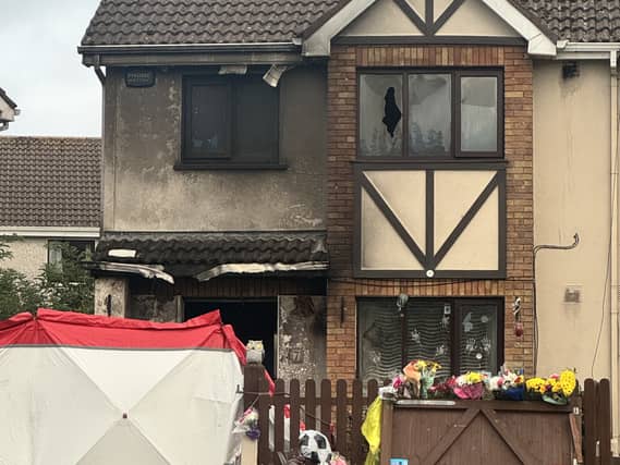 Floral tributes outside the scene of the arson attack at a house in Birchwood, Waterford