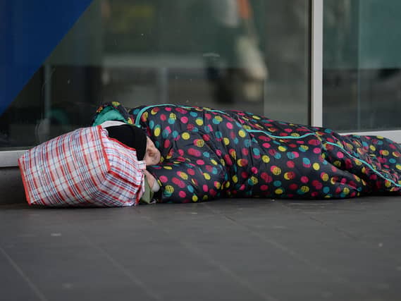 A person in a sleeping bag on the street