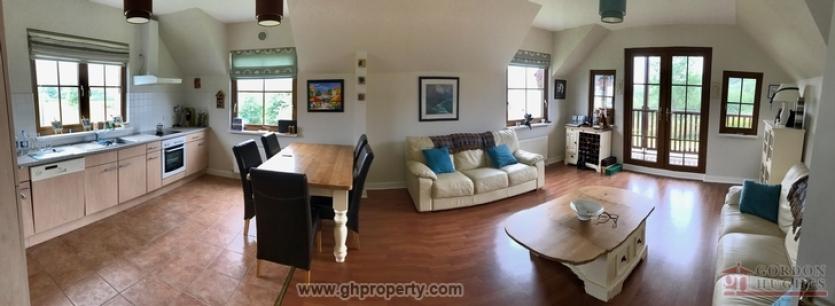 The large dining/kitchen area has doors opening on to a balcony.